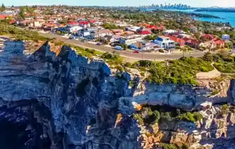 Sydney Harbour in distance as seen aloft from Tasman Sea, overlooking the clifftop suburb of Vaucluse