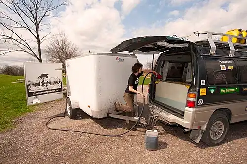 Cloe fills the secondary fuel tank with vegetable oil fuel processed in the trailer during the Driven to Sustain expedition.