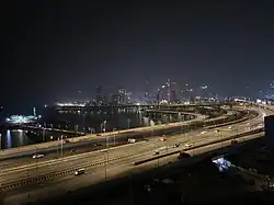 Night view of an illuminated coastal road with Mumbai’s skyline in the background