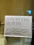 A short sentence written in Barbier's code of two columns of six dots and the translation into Braille using two columns of three dots.