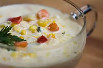 Corn chowder with diced carrot, bell pepper, and parsley
