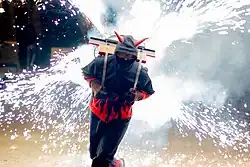 Devil using a backpack equipped with fireworks.