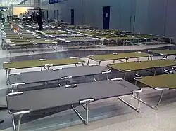 For passengers stranded overnight, secure area at O'Hare International Airport with dimmed lights, cots, pillows, blankets, and toiletries (2008)[29]