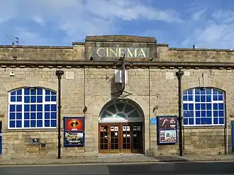 A Yorkshire stone building, with large windows either side of a central porch, with four wooden doors. "Cinema" is written above the porch in gold lettering.