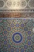 Detail of carved stucco and zellij tilework in the courtyard