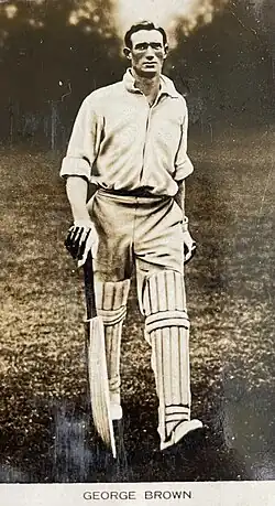 Black and white photo of a man holding a cricket bat.