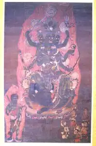 A deity with many heads and arms surrounded by other smaller figures.