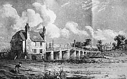 A ramshackle bridge with a cantilevered centre section crossing a river