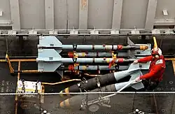 Transportation of two MK-83 1,000 pound bombs from a weapons elevator to the flight deck of the USS George Washington (CVN 73).