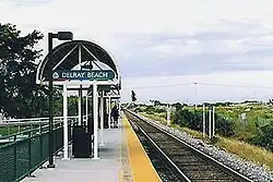 A railway station with a single platform and a half-cylinder metal canopy