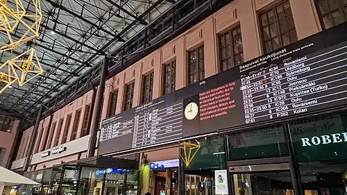 Digital departure board inside a Finnish railway station listing long-distance and sleeper train services, including routes to northern Finland.