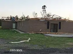 A brick building with its roof removed. Trees can be seen in the background. On the bottom left, it says "NWS BMX".