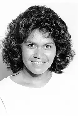 A black-and-white portrait photograph of a smiling woman.