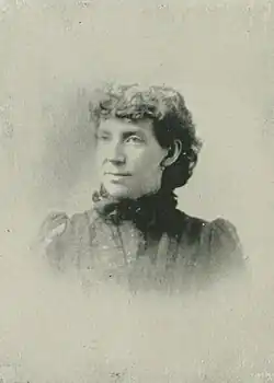 B&W portrait photo of a middle-aged woman with her hair in an up-do
