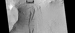 Layers under cap rock of a pedestal crater, as seen by HiRISE under HiWish program. Pedestal crater is within the much larger Tikhonravov Crater. Location is Arabia quadrangle.