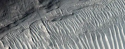 Close view of layers, as seen by HiRISE under HiWish program A ridge cuts across the layers at a right angle.