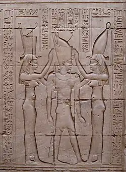 Pharaoh Ptolemy VIII between the goddesses Wadjet (symbolizing lower Egypt) and Nekhbet (symbolizing upper Egypt). Bas-relief on wall of Temple of Edfu, Egypt