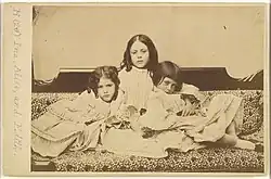 The three Liddell sisters sat on a sofa together, photograph taken by Charles Dodgson/Lewis Carroll in 1858.