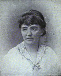 19th-century B&W portrait photo of a woman with her hair in an up-do, wearing a pale, fitted blouse.