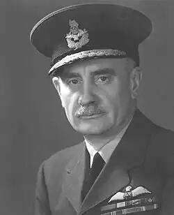 A black and white, head and shoulders portrait of a man in military uniform