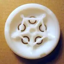 Rear view of a circular pasta extrusion die showing internal support channels feeding the openings