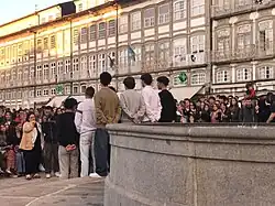 A group of young men outdoors in front of a large crowd