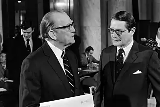 Attorney General Elliot Richardson is pictured Speaking to Senator John Stennis in the columned halls of Congress.