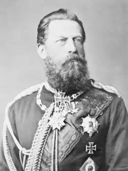 Frederick wears military uniform and has a thick long beard and moustache.