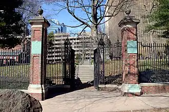Stone gateway with gothic arch leading into a historic cemetery