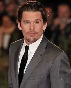 Hawke wearing a suit and tie, looking slightly away from the camera