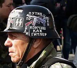 Ukrainian Euromaidan protester wearing Stahlhelm with modified SS insignia, 2014. The inscription says "Putin, think or you'll end up like Hitler".
