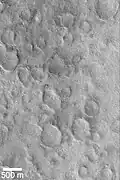 The northern hemisphere appears smooth, but the craters are covered over. Here, a group of craters are partially exposed. Image located in Cebrenia quadrangle.