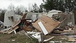 Well-built structures can suffer serious damage, including roof loss, and the collapse of some exterior walls may occur in poorly built structures. Mobile homes, however, are destroyed. Vehicles can be lifted off the ground, and lighter objects can become small missiles, causing damage outside of the tornado's main path. Wooded areas have a large percentage of their trees snapped or uprooted.