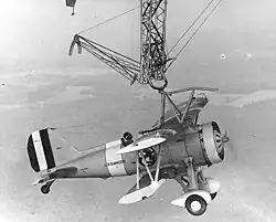 An F9C Sparrowhawk catches the trapeze aboard Macon in 1933
