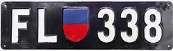 Liechtenstein license plate featuring the Liechtenstein coat of arms in blue and red. These plates were issued between 1924 and 1961.