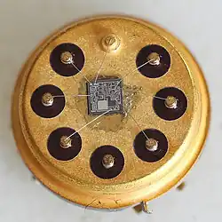 Close-up of square IC die on a gold-plated round 8 pin package