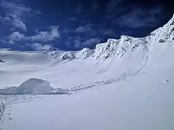 A piece of snow cornice which has fallen off a ridge in early spring