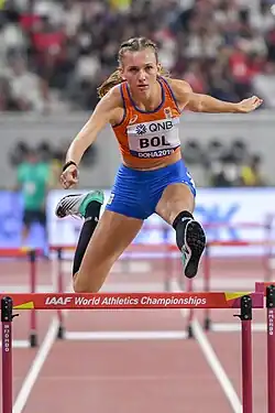Photo of Femke Bol seen from the front while jumping over a hurdle