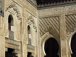 Stucco carving, including muqarnas, along the walls and arches of the courtyard