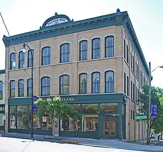 Three story brick building with wood trim over the retail ground floor
