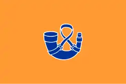 A blue gunpowder horn with a white border against a orange background.