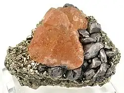 Pink fluorite perched between pyrite (left) and metallic galena (right)