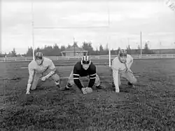 Fleming, Pat Ryan and Terry, players of the Montreal "Nationals" football team, posing with one knee on the ground and in suits.