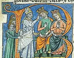 A man and a woman, both wearing a crown, and sitting on a throne with a bishop touching the man's forehead.