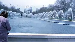 A large fountain-lined pool lined leads to a large, globe-like structure representing Earth.