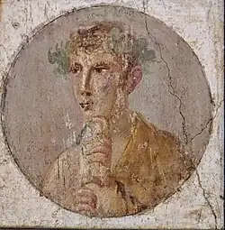 Roman portrait: in a circular tondo, the face of a well-groomed young man wearing a laurel wreath and holding a scroll