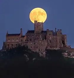 Full moon rising directly above the castle