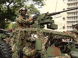 A small patrol unit from the Gerak Khas, the Malaysian Army Special Forces, on standby inside their Special Operations Vehicle (SOV) while waiting for their turn during the 2014 Merdeka Day parade. All members are seen wearing digital combat uniforms with Pro-Tec bump helmets.