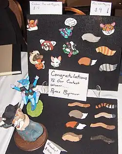 An open binder of animal-themed pins with some sculptures of anthropomorphic animals on display