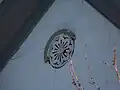 "Circular gable vent with a chrysanthemum-like piercing pattern"